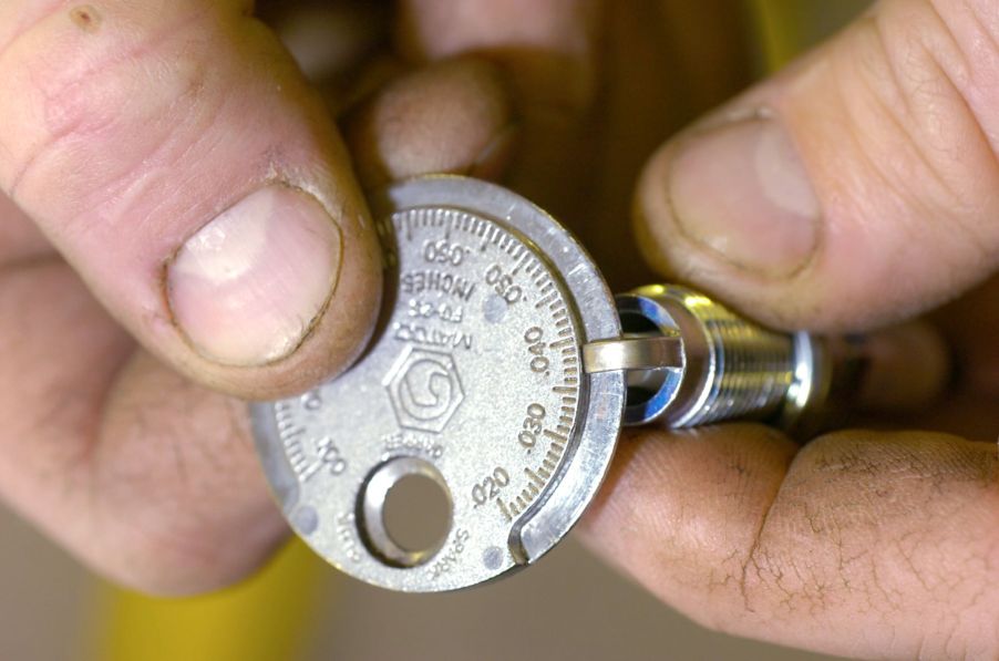 Chuck Robinson checking the gap on a platinum spark plug for a Volkswagen Jetta