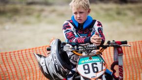 A child sitting on a dirt bike motorcycle during a motocross championship in Tavricheskoye of the Omsk Region in Russia