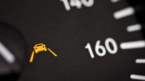 Detail shot of a lane departure warning icon on a Mercedes dashboard.