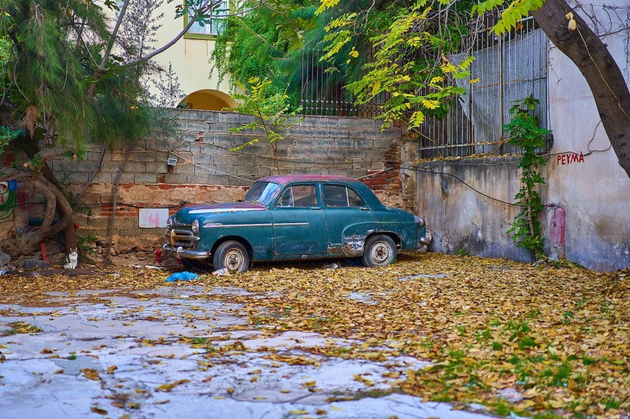 An old abandoned car left in a parking lot