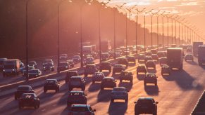 A crowded rush hour highway filled with commuters at sunset.