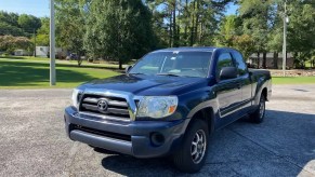 Front of a 2008 Toyota Tacoma truck in front of a row of trees.