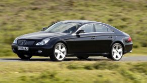 A black 2005 Mercedes CLS 500 driving down a country road