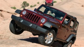 A red Jeep Wrangler climbing up a steep desert path. Jeep Wrangler years to avoid