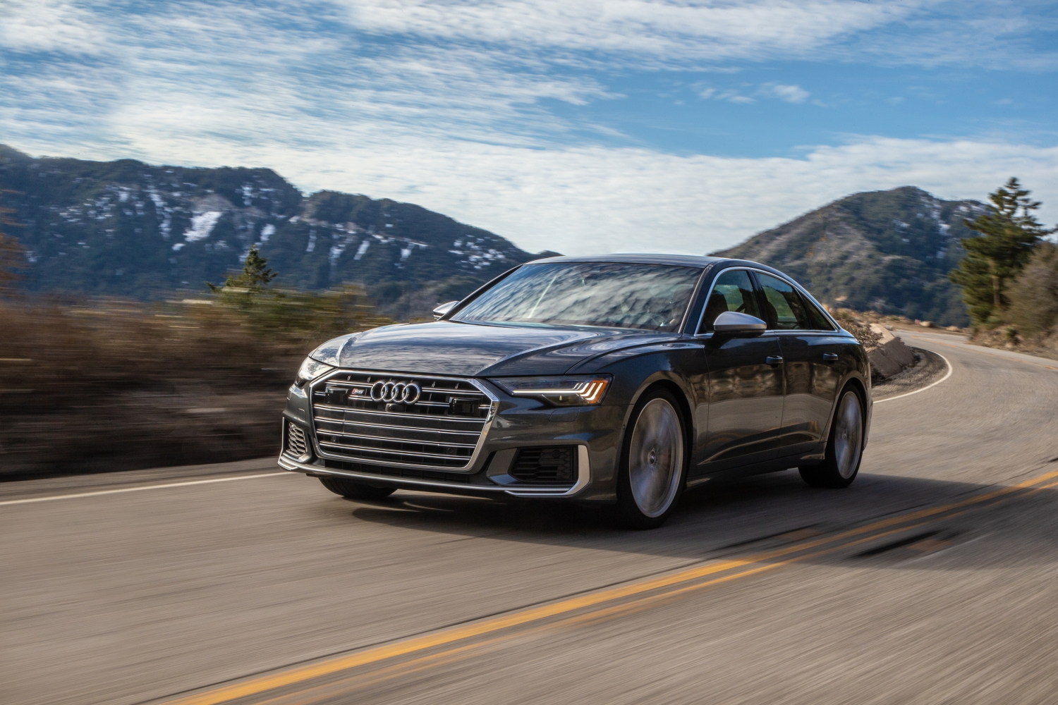 Black 2022 Audi S6 driving on winding mountain road