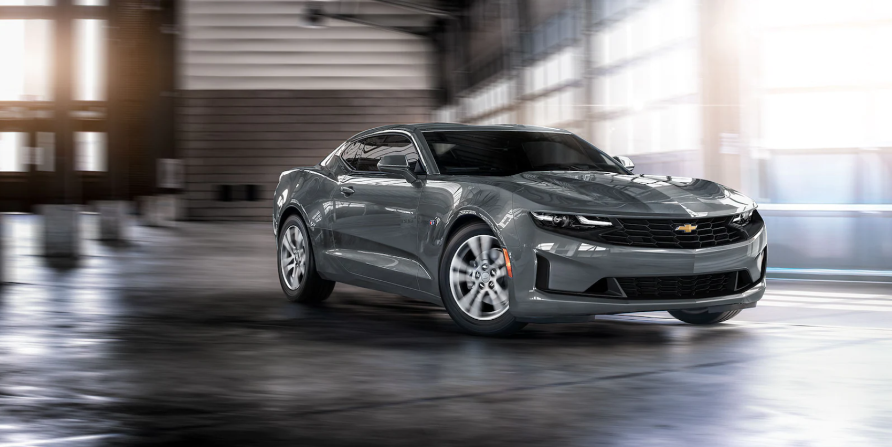 2022 Chevy Camaro muscle car in gray driving through a parking garage hangar