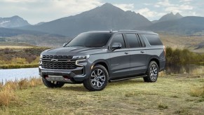 A gray 2022 Chevy Suburban parked in front of a mountain.