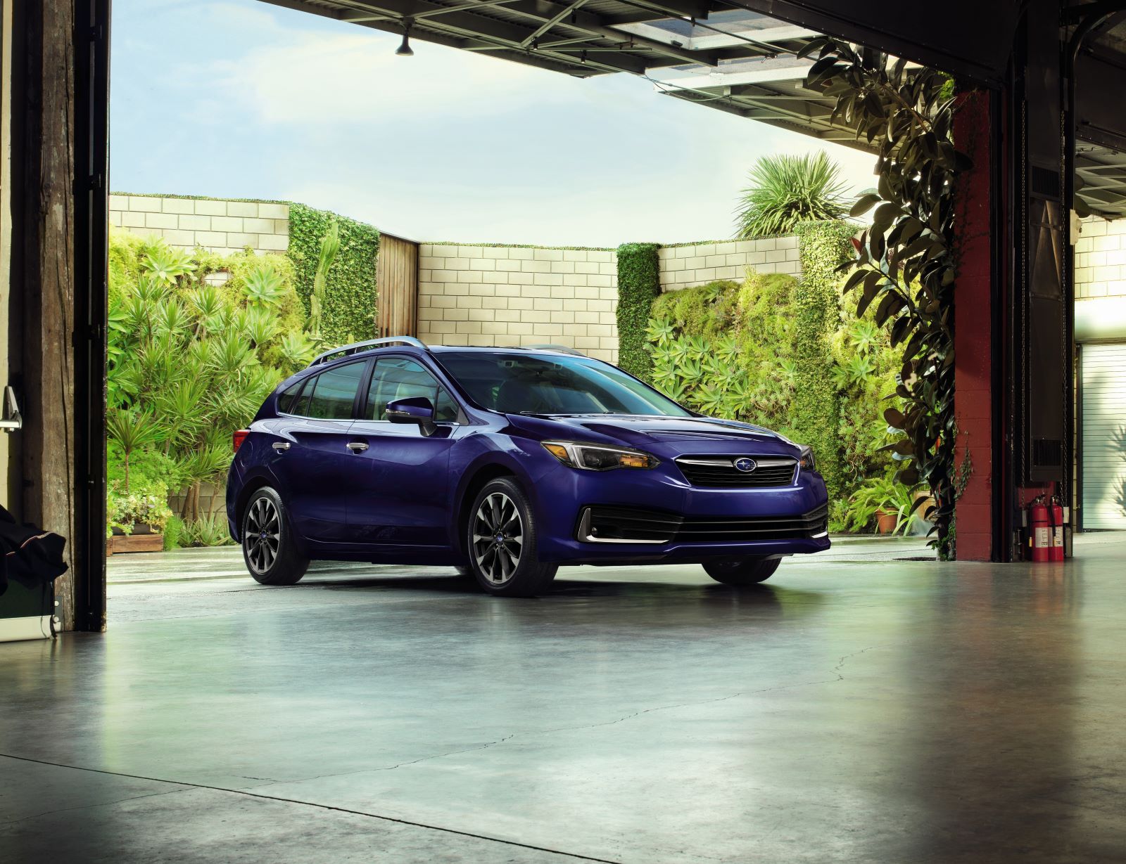 Front angle view of the 2022 Subaru Impreza 5-door in dark blue, set against a city backdrop