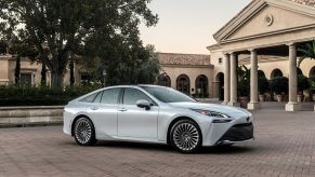 2022 Toyota Mirai Limited hydrogen fuel cell sedan in Oxygen White parked on a brick plaza