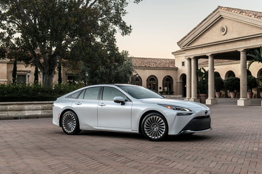 2022 Toyota Mirai Limited hydrogen fuel cell sedan in Oxygen White parked on a brick plaza