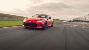 Red 2022 Toyota GR86 sports car driving along a track, toward the camera