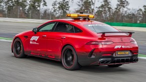 A 3/4 rear view of the red Mercedes-AMG GT 63 S 4Matic+ F1 Medical Car driving on a race track.