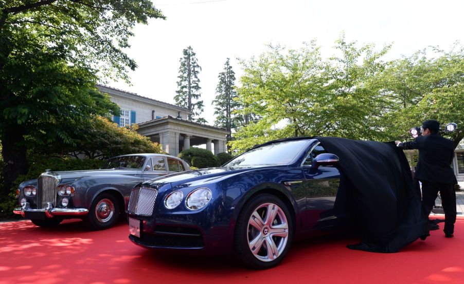 1964 Bentley S3 Saloon parked on a red carpet next to the unveiling of the new Bentley Flying Spur V8 in Japan