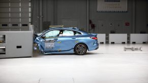 A profile view of a blue BMW 2 Series Gran Coupe being crash tested at the IIHS testing facility.