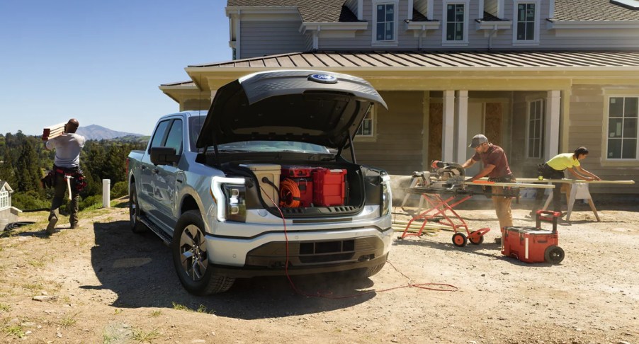 A gray 2022 Ford F-150 Lightning is parked with its frunk open.