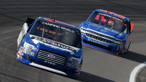 Ford F-150 and Chevy Silverado NASCAR trucks racing during Camping World Truck Series in Madison, Illinois