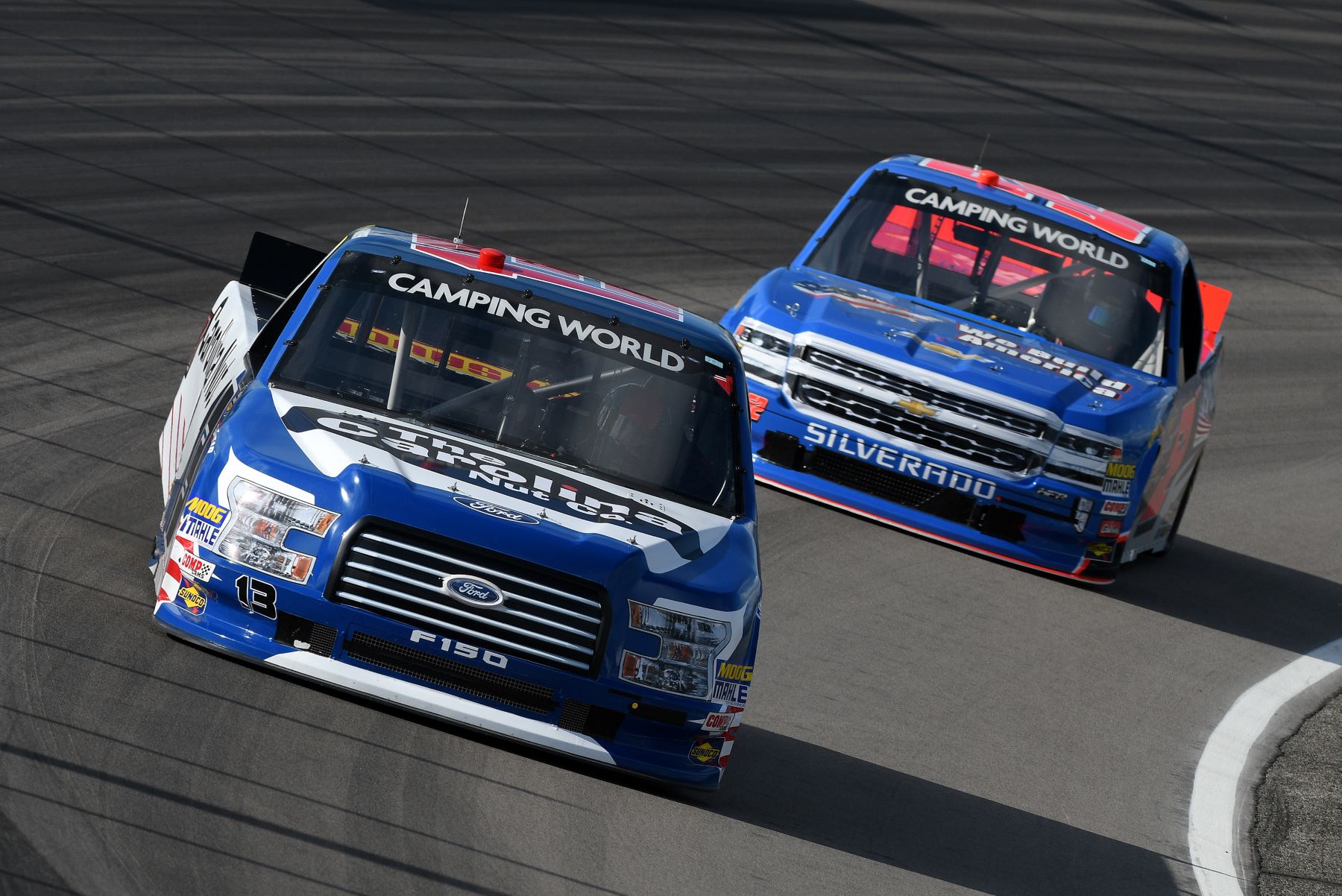 Ford F-150 and Chevy Silverado NASCAR trucks racing during Camping World Truck Series in Madison, Illinois