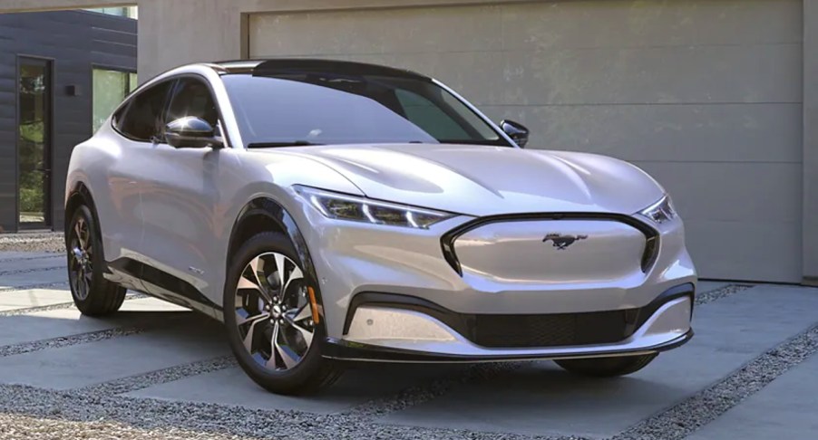 A white Ford Mustang Mach-E electric SUV is parked.