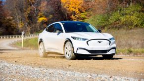 Ford Mustang Mach-E with Ice White Appearance Package undergoing a durability test on a dirt and gravel road