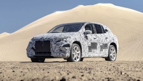 Front view of camouflage-wrapped 2023 Mercedes-Benz EQS SUV, highlighting its release date and price