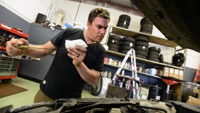 Mechanic inspects oil level of a vehicle via the dipstick