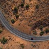 Drone aerial view of winding road and red car in Utah.