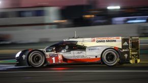 A profile view of a Porsche 919 LMP race car driving at night during the 2017 24 Hours of Le Mans race.