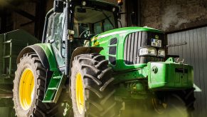 Large 4WD John Deere tractor parked in a barn.