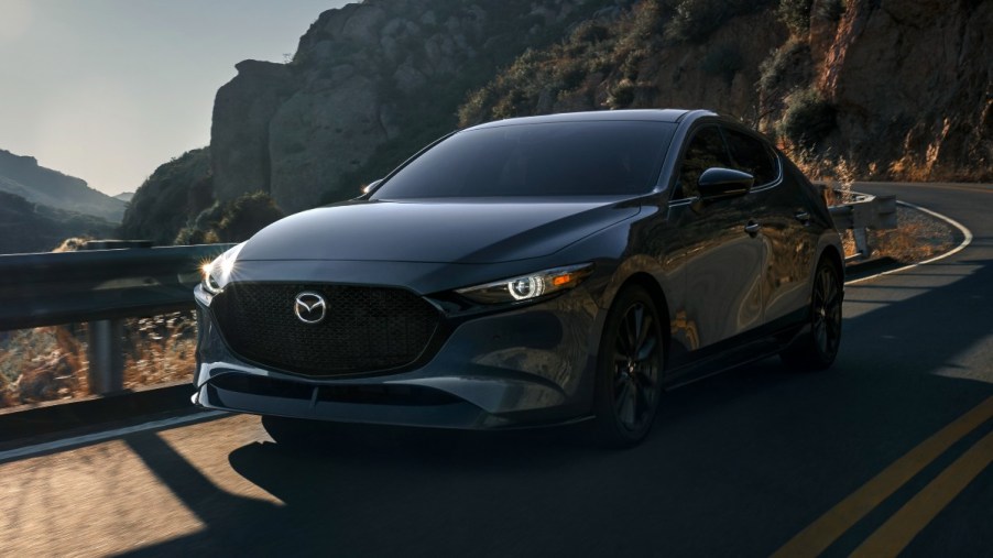 Machine Gray Metallic 2022 Mazda3 driving on a mountain road