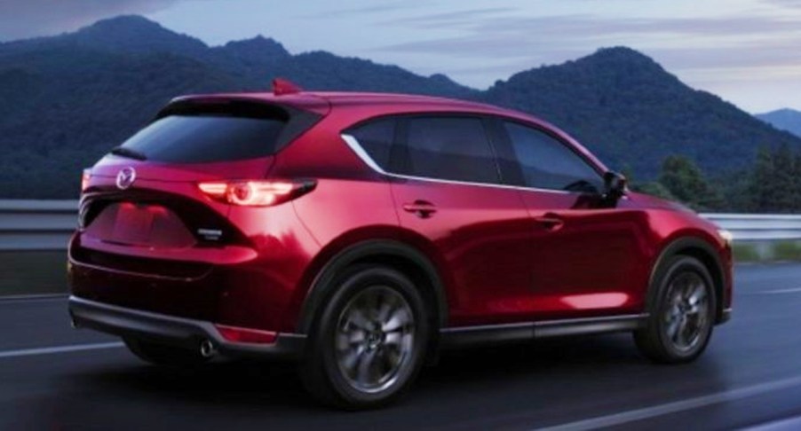 A red 2022 Mazda CX-5 small SUV is driving on the road.