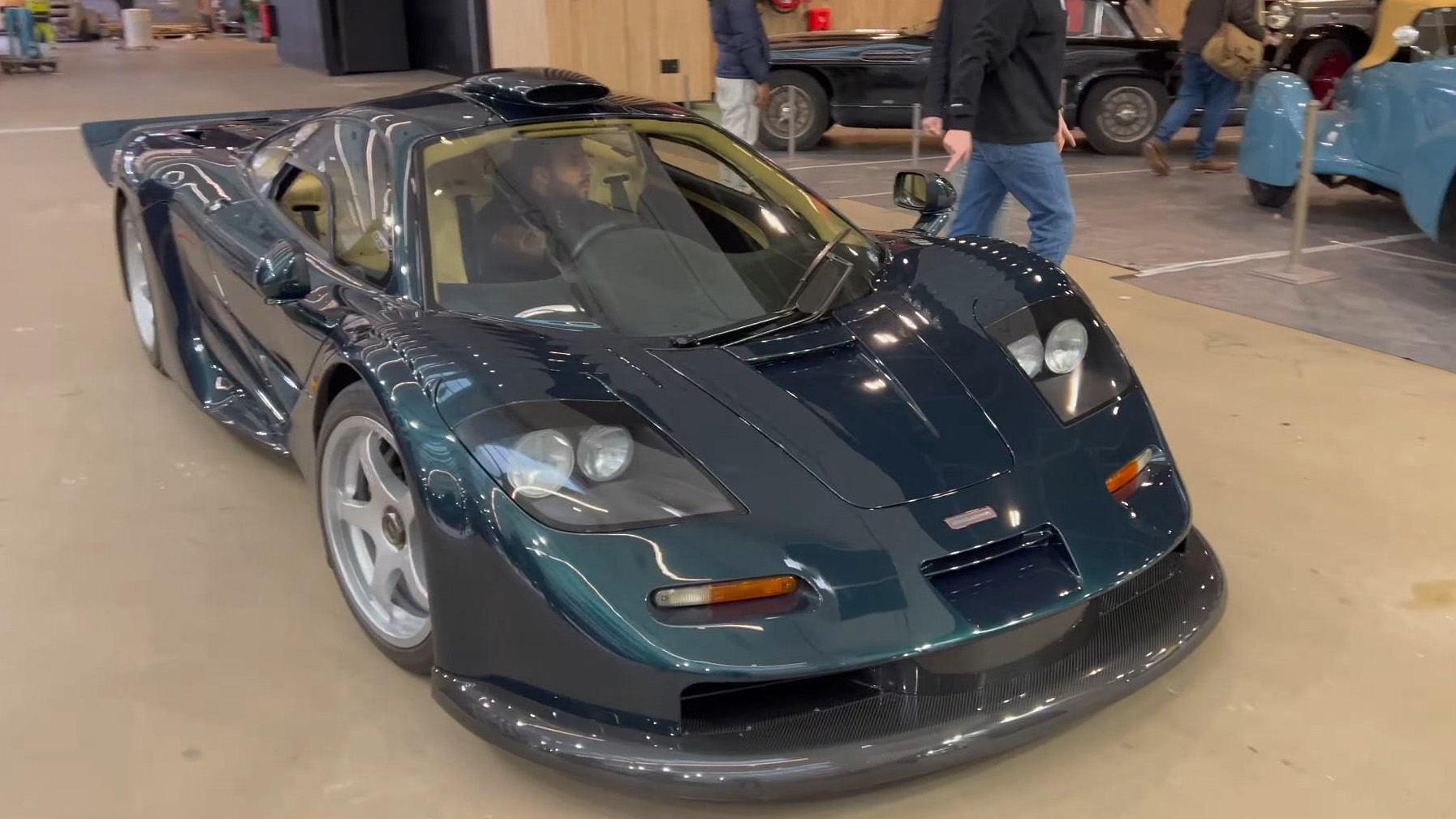 Green McLaren F1 GT Homologation car driving into Paris Retromobile car show 