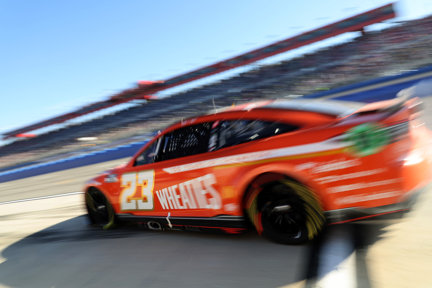 Red race car moving fast down a track.