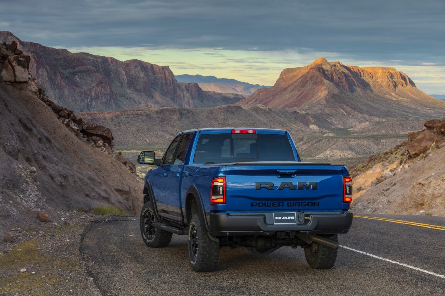 Blue Dodge Power Wagon parked on a road above a sandy mountain range.