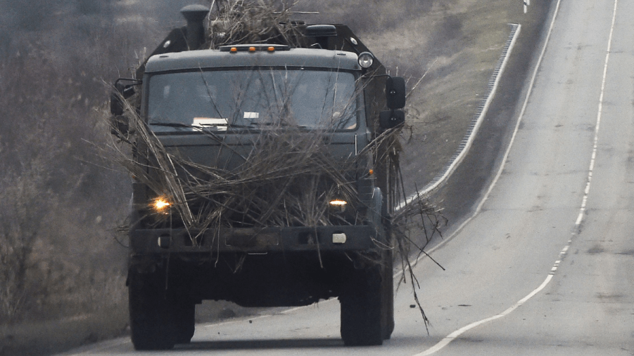 Russian military truck with branches, highlighting use of wood logs for armor for the invasion of Ukraine