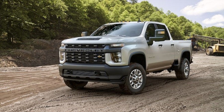 A beige 2022 Chevy Silverado driving through the woods.