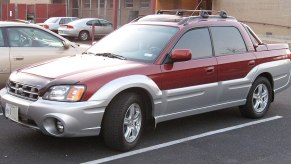 A red Subaru Baja sits in a parking lot, showing off its compact size as a small truck.