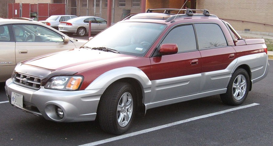 A red Subaru Baja sits in a parking lot, showing off its compact size as a small truck.