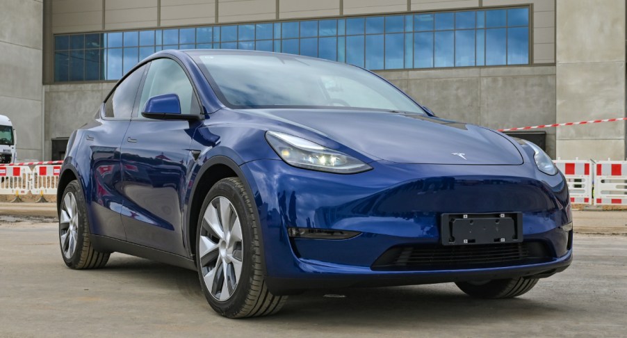 A blue Tesla Model Y is parked.