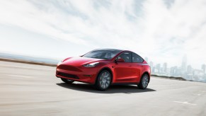 A red Tesla Model Y is driving on the road.