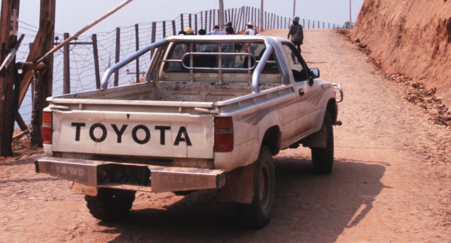 A white Toyota Pickup is driving off-road.