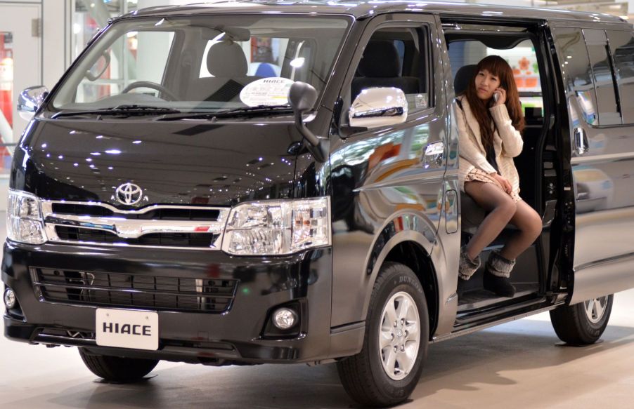 The Toyota Hiace minivan seen at the Tokyo showroom as a woman talks on the phone inside its cabin