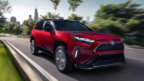 A red 2022 Toyota RAV4 Prime is driving on the road.