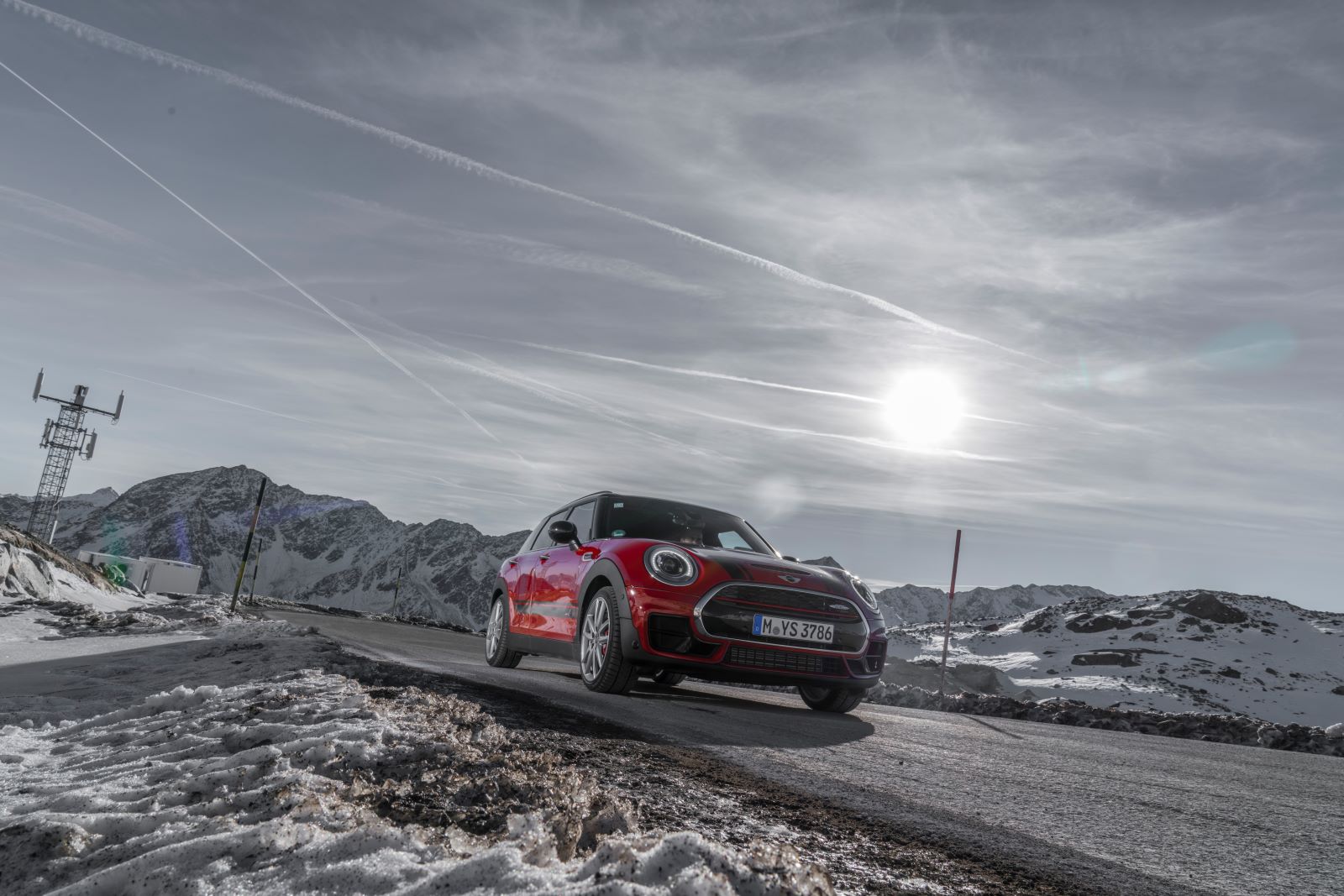 Front view of a 2022 MINI Clubman in red, driving along a road in the winter