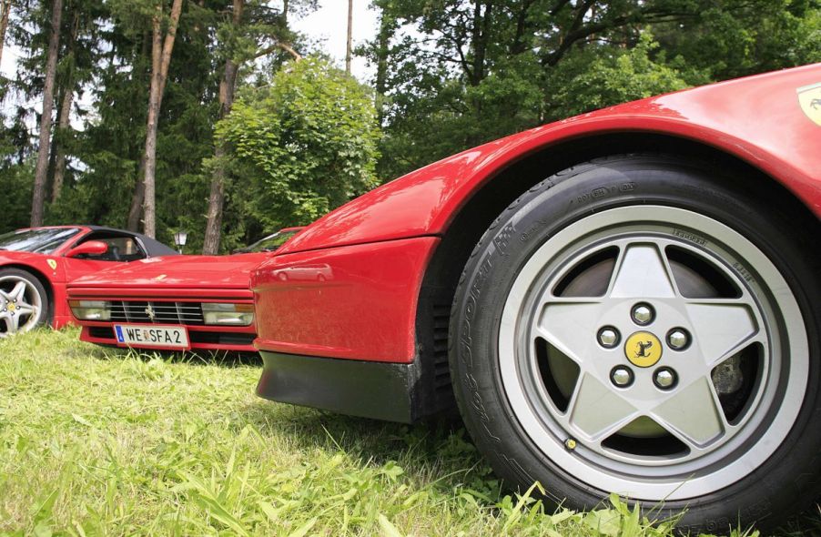 Close-up shot of a Ferrari 328 GTS sports car with the iconic five-point star hubcap