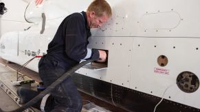 A flight technician plugging a hose into the jet-propelled British Bloodhound LSR car to refuel it