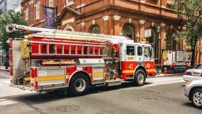 A fire engine truck driving through a city intersection.