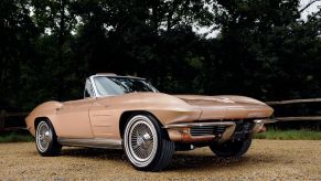 1964 Chevrolet Corvette Stingray convertible model parked on a gravel forest path