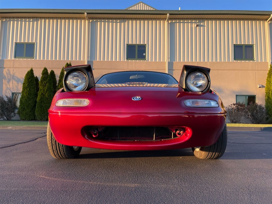 Front of red 1994 Mazda Miata with headlights up