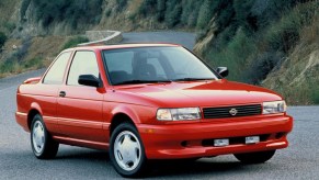 A red 1995 Nissan Sentra SE-R on a canyon road