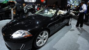 A worker dusts a black 2010 Jaguar XKR Convertible at the 2009 LA Auto Show